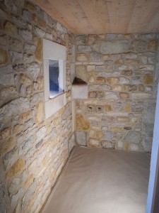 Habillage d'une salle de bain, en pierres à maçonner multicolores avec encadrement de fenêtre et tablette